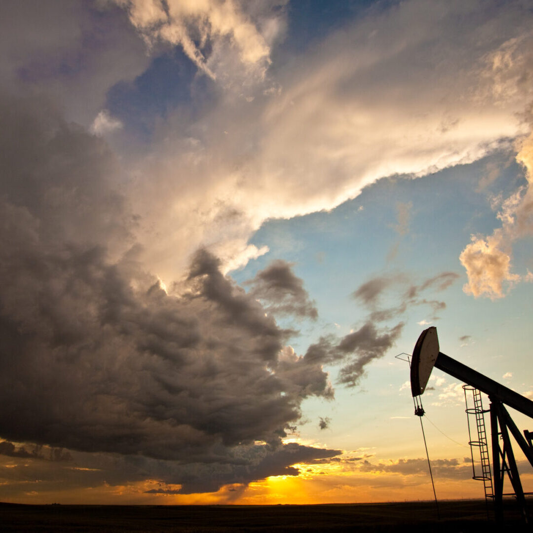 A pumpjack on the prairie. Alberta, Canada. Silhouette. Dramatic sunset sky. Crude oil exporting is a major economic driver of Alberta. This oil rig is located near the oil sands or tarsands near Fort McMurray. Oil industry image with dramatic and stormy sky - a fitting depiction of a stormy industry!